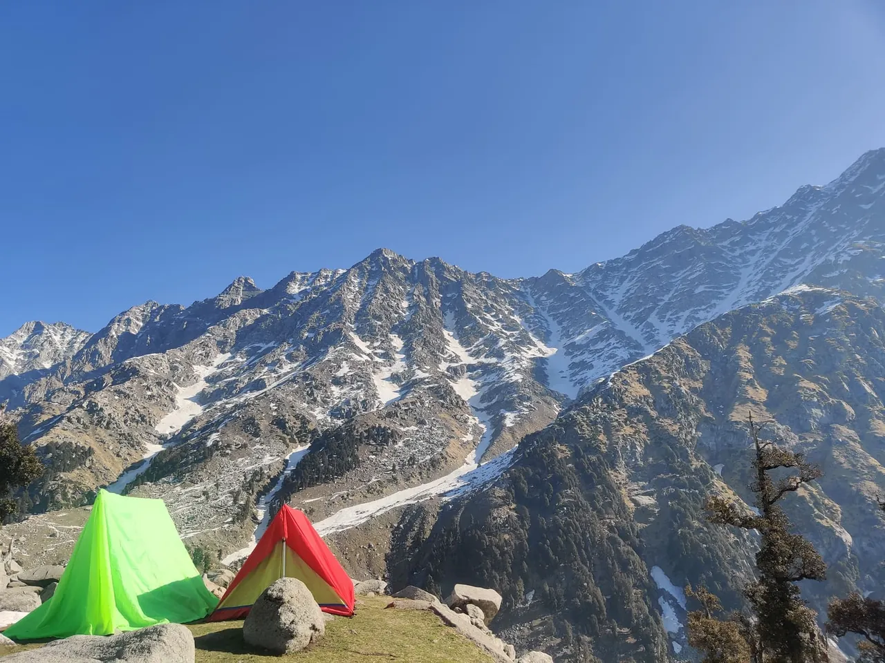 Tents pitched beneath snow-capped mountains